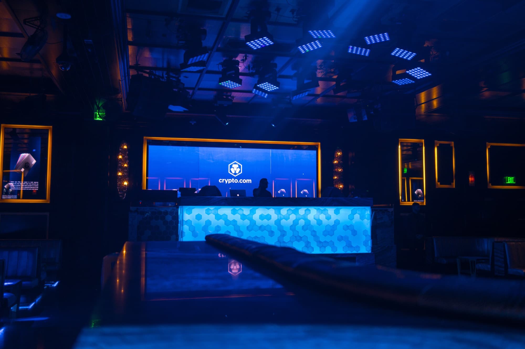 A dark club lit blue with a Crypto.com screen above the bar in Las Vegas